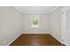 Simple bedroom with hardwood flooring, crown molding and single window providing natural light at 215 Westridge Dr, Raleigh, NC 27609