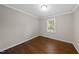 Neutral bedroom with hardwood flooring, crown molding and single window providing natural light at 215 Westridge Dr, Raleigh, NC 27609