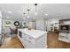 Bright, open kitchen with quartz island, wood floors, stainless appliances and view to dining area and living room at 215 Westridge Dr, Raleigh, NC 27609