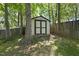 A backyard utility shed is nestled amongst mature trees and a wooded fence line at 215 Westridge Dr, Raleigh, NC 27609