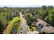 Aerial view of a quiet residential street featuring well-manicured lawns, lush trees, and nearby lake at 221 Hammond Wood Pl, Morrisville, NC 27560