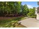 Scenic backyard featuring lush greenery, a concrete patio, and trees at 221 Hammond Wood Pl, Morrisville, NC 27560