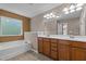 Bathroom featuring double vanities, soaking tub, and a large mirror enhancing the space's appeal at 221 Hammond Wood Pl, Morrisville, NC 27560