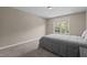 Neutrally decorated bedroom with carpet flooring, a queen bed, and a window with natural light at 221 Hammond Wood Pl, Morrisville, NC 27560