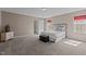 Well-lit bedroom with neutral walls, carpet and a comfortable bed and black cushioned ottoman at 221 Hammond Wood Pl, Morrisville, NC 27560