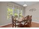 A formal dining room with a large window, a dark wood table, seating for six, and hardwood floors at 221 Hammond Wood Pl, Morrisville, NC 27560