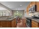 A kitchen showcasing granite countertops, stainless steel appliances, wood cabinets, and a dining area in the background at 221 Hammond Wood Pl, Morrisville, NC 27560