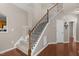 View of the carpeted staircase with decorative iron railing and stained handrail, complemented by hardwood flooring at 221 Hammond Wood Pl, Morrisville, NC 27560