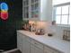 Stylish bar area featuring white cabinets, a sleek countertop, and unique neon decor at 222 Oak Branch Trl, Garner, NC 27529
