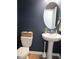 Modern bathroom with a pedestal sink, oval mirror, and navy blue walls at 222 Oak Branch Trl, Garner, NC 27529