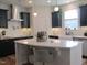 Modern kitchen features sleek black cabinets, stainless steel appliances, and a spacious white quartz countertop island at 222 Oak Branch Trl, Garner, NC 27529