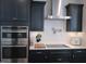 The kitchen showcases dark cabinetry, stainless steel appliances, a white backsplash, and a quartz countertop island at 222 Oak Branch Trl, Garner, NC 27529