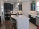 Spacious kitchen features black cabinetry, a stainless steel range hood, an island with seating, and a farmhouse sink at 222 Oak Branch Trl, Garner, NC 27529