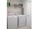 Efficient laundry room with washer, dryer, shelving, and space-saving ironing board at 222 Oak Branch Trl, Garner, NC 27529