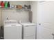 Bright laundry room features a washer, dryer, and storage shelf above at 222 Oak Branch Trl, Garner, NC 27529