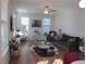 Sunlit living room featuring hardwood floors, a ceiling fan, and stylish modern decor at 222 Oak Branch Trl, Garner, NC 27529