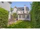 Back of house featuring manicured lawn, mature trees and a screened in porch at 2306 Byrd St, Raleigh, NC 27608
