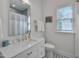 Well-lit bathroom with white vanity, chrome fixtures, and a decorative black and white tiled floor at 2306 Byrd St, Raleigh, NC 27608