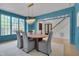 Bright dining room with blue walls, a crystal chandelier, and seating for six next to the staircase at 2306 Byrd St, Raleigh, NC 27608