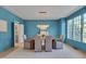 Elegant dining room with blue walls, a chandelier, and large windows offering ample natural light at 2306 Byrd St, Raleigh, NC 27608