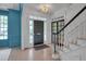 Bright foyer featuring a staircase, white trim, beautiful light fixture, and a glimpse of a blue accent wall at 2306 Byrd St, Raleigh, NC 27608