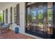 Inviting front door with detailed glass panels, flanked by seating area on the red brick porch at 2306 Byrd St, Raleigh, NC 27608