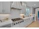 Modern kitchen with white cabinets, stainless steel appliances, a range hood, and a view from the window at 2306 Byrd St, Raleigh, NC 27608