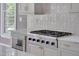 Close up on a kitchen featuring white cabinets, stainless steel appliances, and a subway tile backsplash at 2306 Byrd St, Raleigh, NC 27608