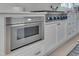 Kitchen with stainless appliances, gas range and marble counter tops, and white custom cabinets at 2306 Byrd St, Raleigh, NC 27608
