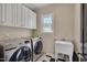 Well-lit laundry room with front-loading washer and dryer, and utility sink at 2306 Byrd St, Raleigh, NC 27608
