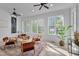 Bright sunroom with large windows, comfortable seating, ceiling fans, and travertine tile floors at 2306 Byrd St, Raleigh, NC 27608