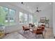 Relaxing sunroom featuring many bright windows, light tile flooring, and a cooling ceiling fan at 2306 Byrd St, Raleigh, NC 27608