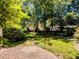 Well-maintained backyard featuring brick patio, lush green grass, and mature trees at 2405 Flints Pond Cir, Apex, NC 27523