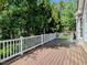 Spacious deck with white railing overlooking lush green trees, perfect for outdoor living at 2405 Flints Pond Cir, Apex, NC 27523
