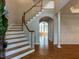 A grand foyer has a staircase, wood floors, and an arched entryway at 2405 Flints Pond Cir, Apex, NC 27523