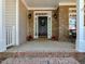 A welcoming front porch has brick accents and black door with surrounding white trim at 2405 Flints Pond Cir, Apex, NC 27523