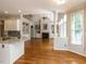 Open concept living room with hardwood floors, a fireplace and a kitchen island at 2405 Flints Pond Cir, Apex, NC 27523