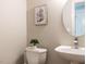 Small powder room includes a toilet, sink, mirror, and wall decor at 2405 Flints Pond Cir, Apex, NC 27523