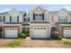 Charming townhome with a single-car garage, manicured landscaping, and neutral siding under a clear blue sky at 2609 Asher View Ct, Raleigh, NC 27606