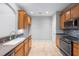 A kitchen featuring wooden cabinets, gray countertops, tile backsplash, and black appliances on a tile floor at 2609 Asher View Ct, Raleigh, NC 27606