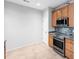 A kitchen featuring wooden cabinets, gray countertops, black appliances, and tile backsplash at 2609 Asher View Ct, Raleigh, NC 27606