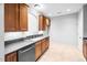 Kitchen featuring wooden cabinets, gray countertops, tile flooring, and stainless steel dishwasher at 2609 Asher View Ct, Raleigh, NC 27606