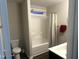 Bright bathroom featuring a shower and tub combination, a toilet, and a black vanity with white countertop at 267 Darecrest Ln, Wendell, NC 27591