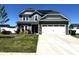 Charming two-story home with stone accents, attached two-car garage, and well-manicured lawn under clear blue skies at 267 Darecrest Ln, Wendell, NC 27591