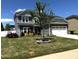 Beautiful two-story home featuring well-maintained lawn with a mature tree in the front yard on a sunny day at 267 Darecrest Ln, Wendell, NC 27591