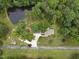 Aerial view of a property featuring a pond with fountain and house with mature trees at 2913 Escondido Farm Rd, Garner, NC 27529