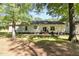 The home's back exterior boasts a neutral palette and brick patio, framed by mature trees and a lush yard at 2913 Escondido Farm Rd, Garner, NC 27529