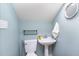 Cozy powder room with pedestal sink, toilet and black metal shelf at 2913 Escondido Farm Rd, Garner, NC 27529