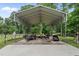 Large carport structure in a wooded area with a trailer, lumber, and storage containers at 2913 Escondido Farm Rd, Garner, NC 27529