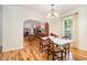 View of the dining room featuring hardwood floors, a modern light fixture, and an open view to the kitchen at 2913 Escondido Farm Rd, Garner, NC 27529
